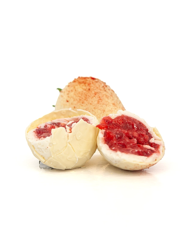 Biele tortičky v tvare jahody – jedno rozrezané v popredí a druhé celé vzadu, zrelé jahody so smotanovým krémom, štýlové, výrazné a chutné