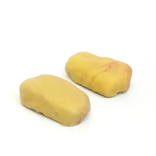 Pistáciový dezert v tvare pistácie – jemný dacquoise, pistáciová pasta a krémový ganache zo 100 % pistácií, pohľad zhora pod miernym uhlom