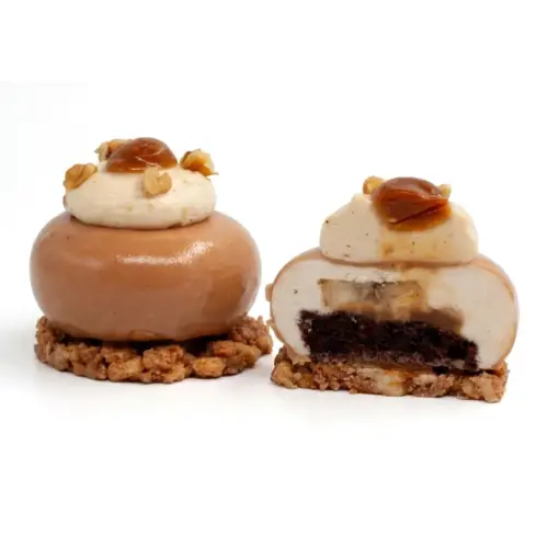Banánový dezert – celý mousse zákusok vľavo a rozrezaný vpravo, s čokoládovým piškótom, karamelizovaným banánom, banánovým mousse, šľahaným ganache s arašidovou pastou a karamelom.